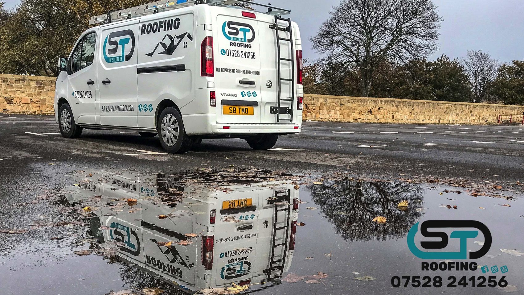 The white S.T Roofing van with its logo, parked beside a stone wall